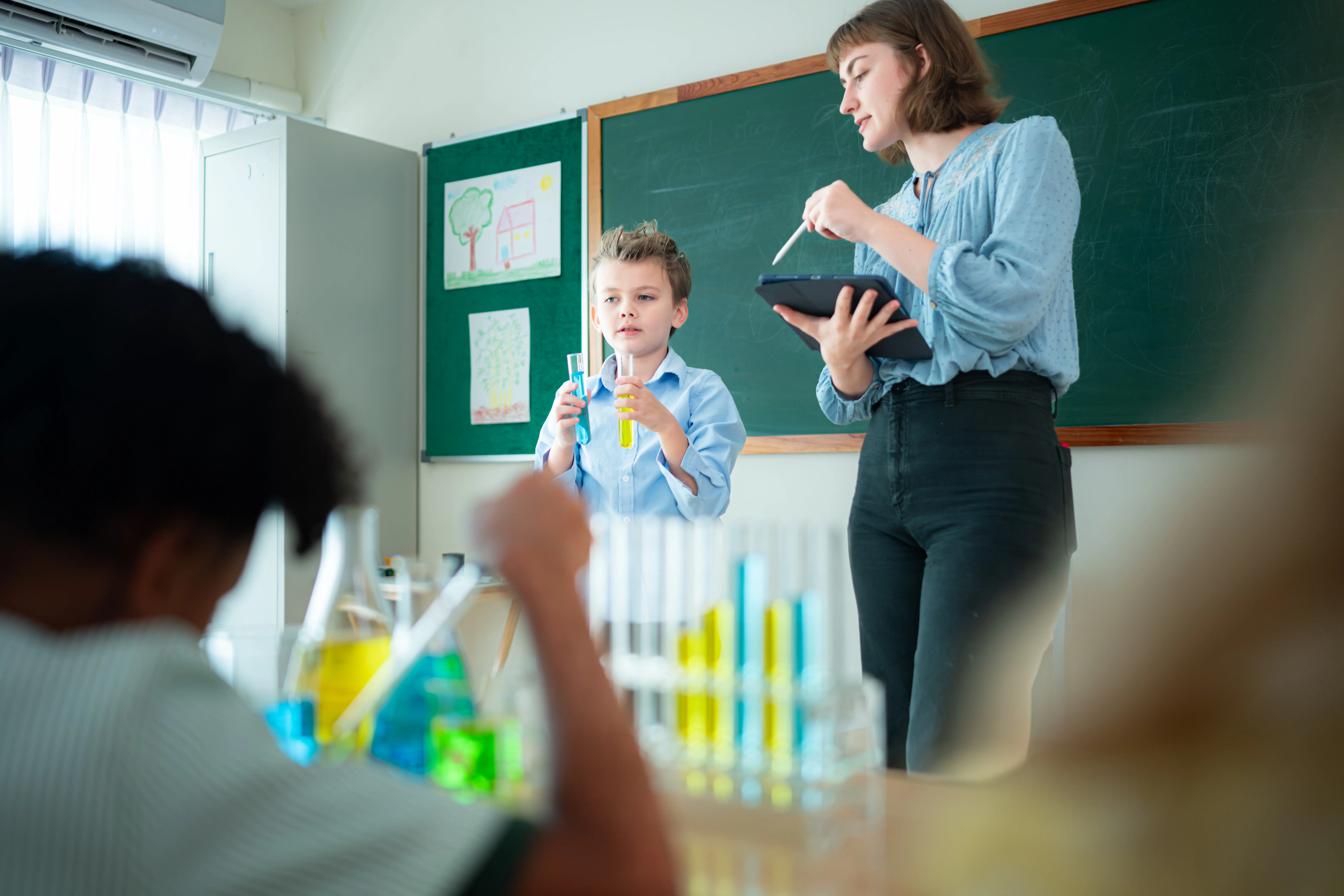 Lehrer und Schüler lernen und experimentieren in den Naturwissenschaften in einem naturwissenschaftlichen Klassenraum in einer Schule.
